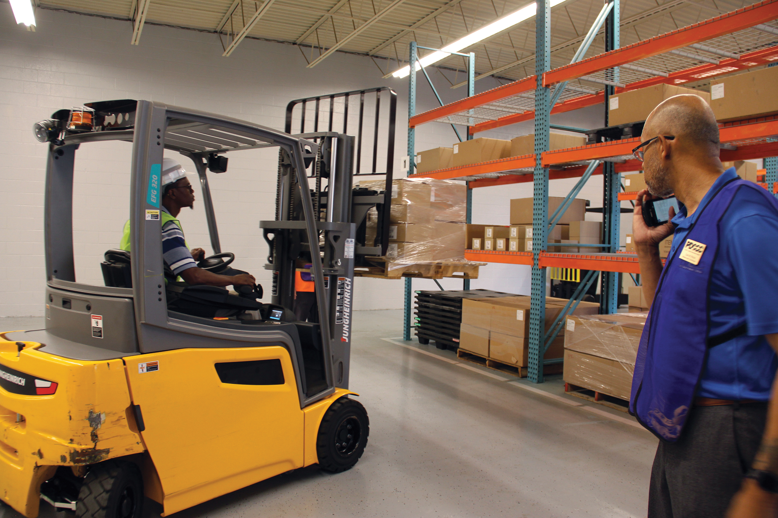 Man in warehouse sitting in forklift