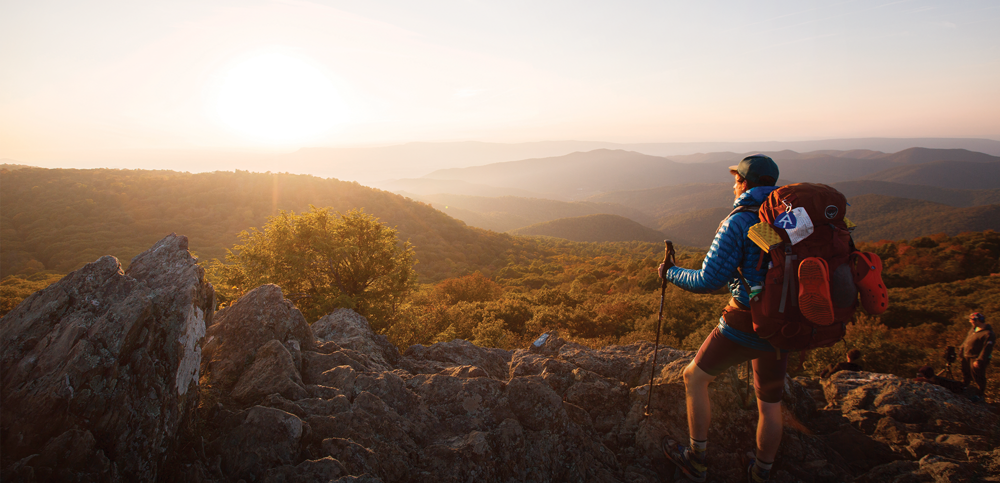 Hiker on a mountain in Shenandoah National Park looking at the sunrise