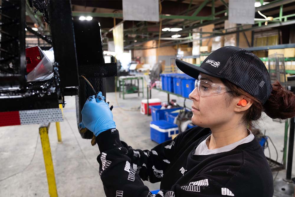 Woman fixing trailer in manufacturing setting