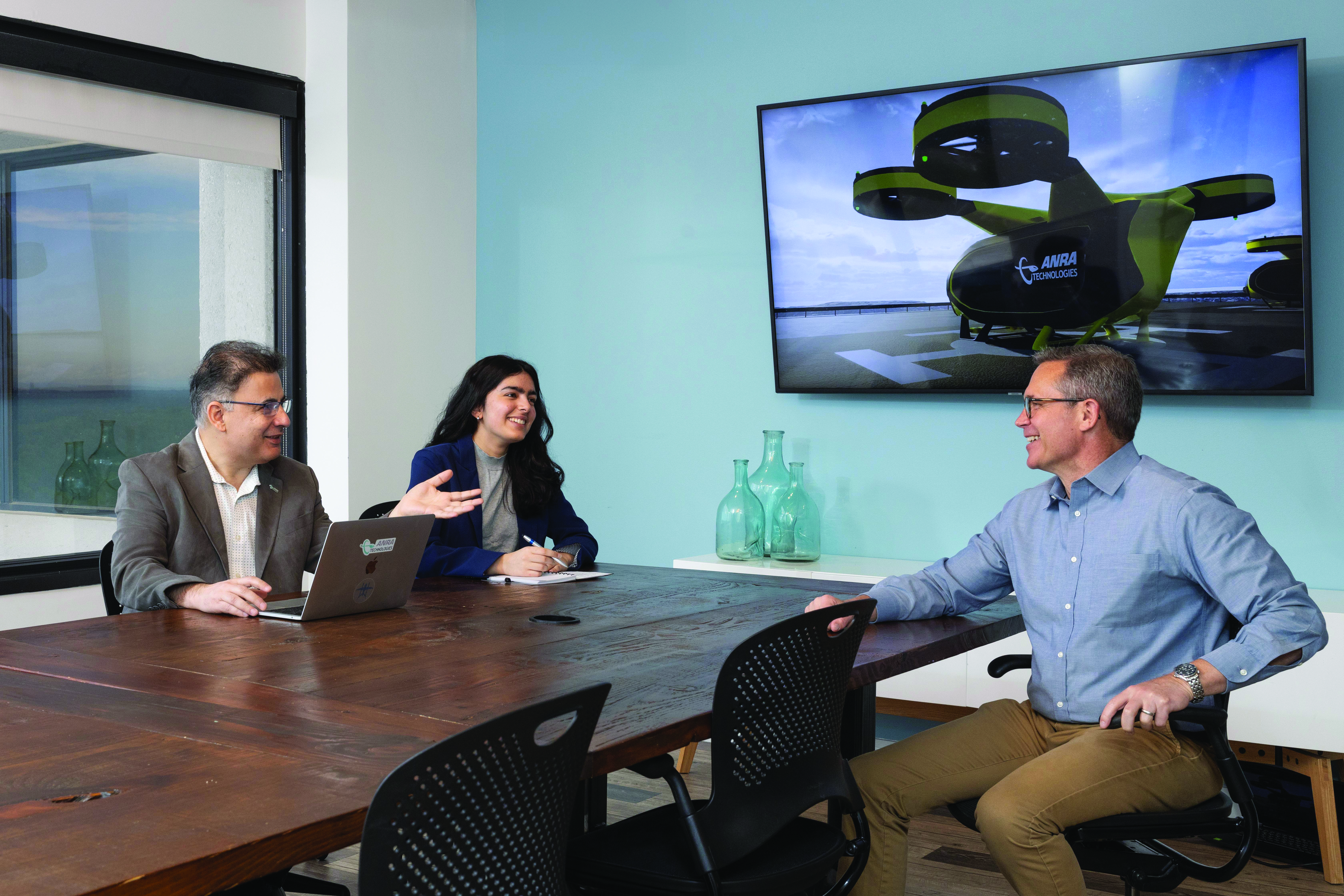 3 ANRA Technology employees sitting at a conference table 