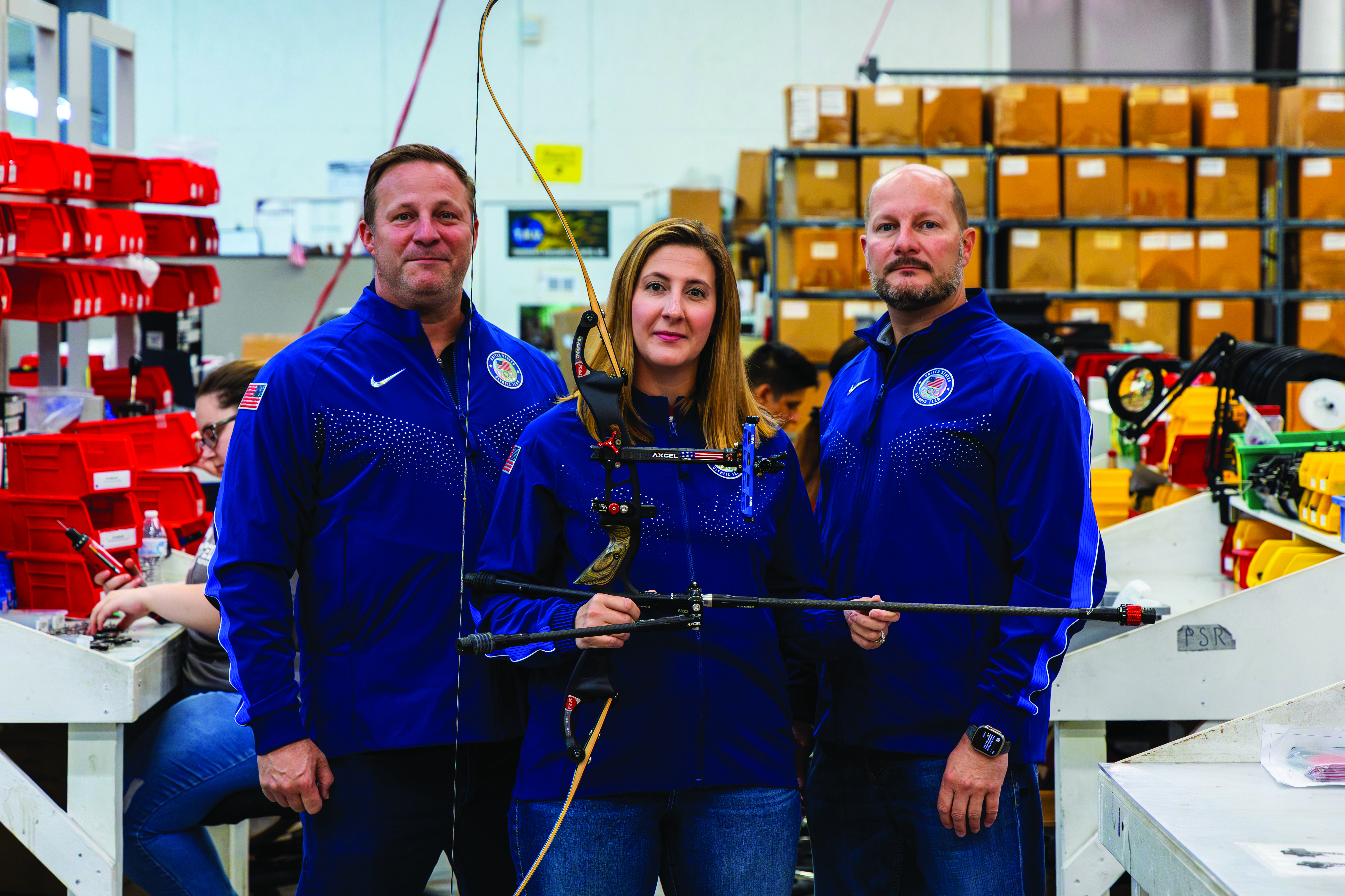 Three T.R.U. ball employees holding a bow and arrow 