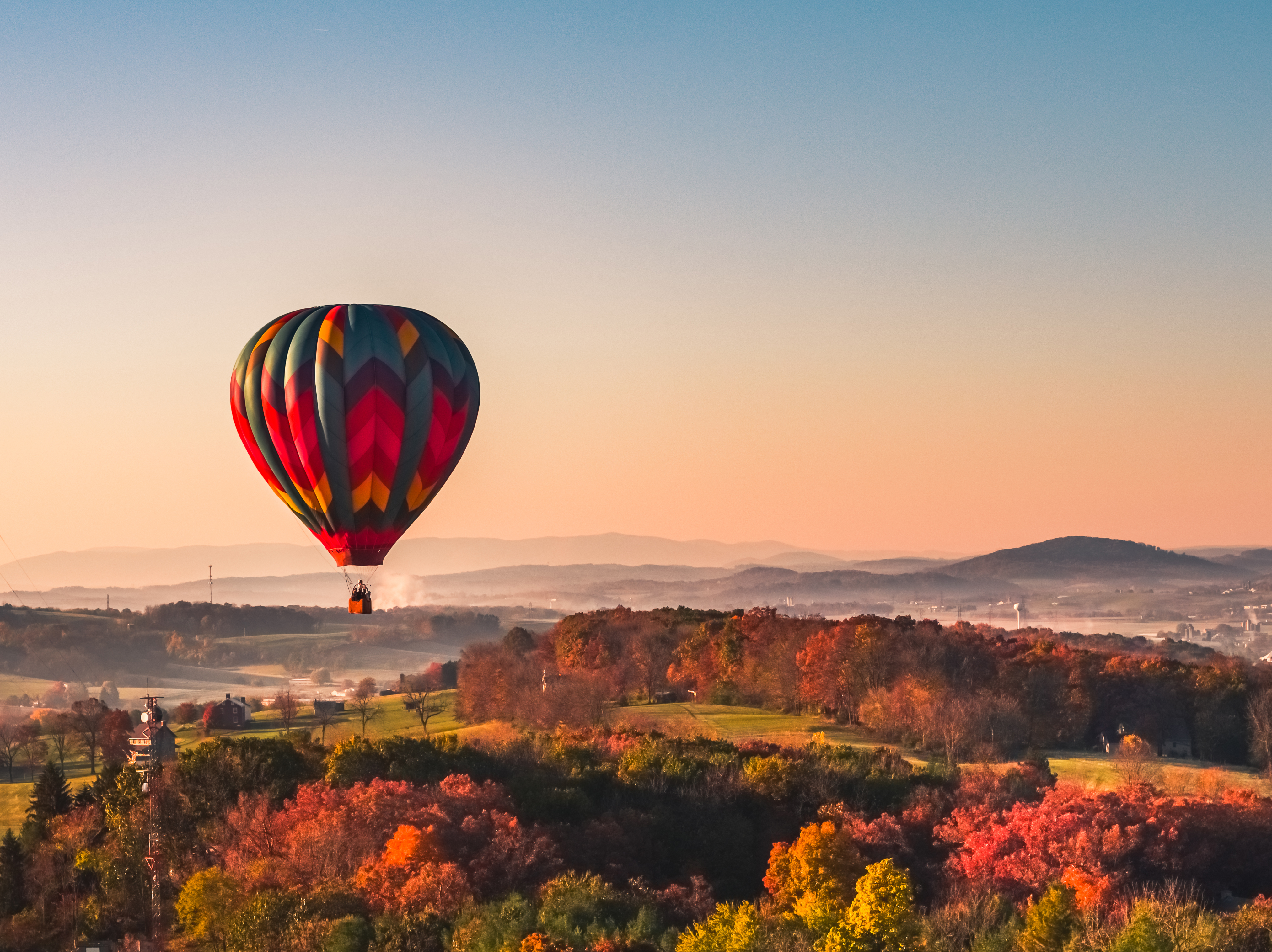 Hot Air Balloon in the sunset flying over trees