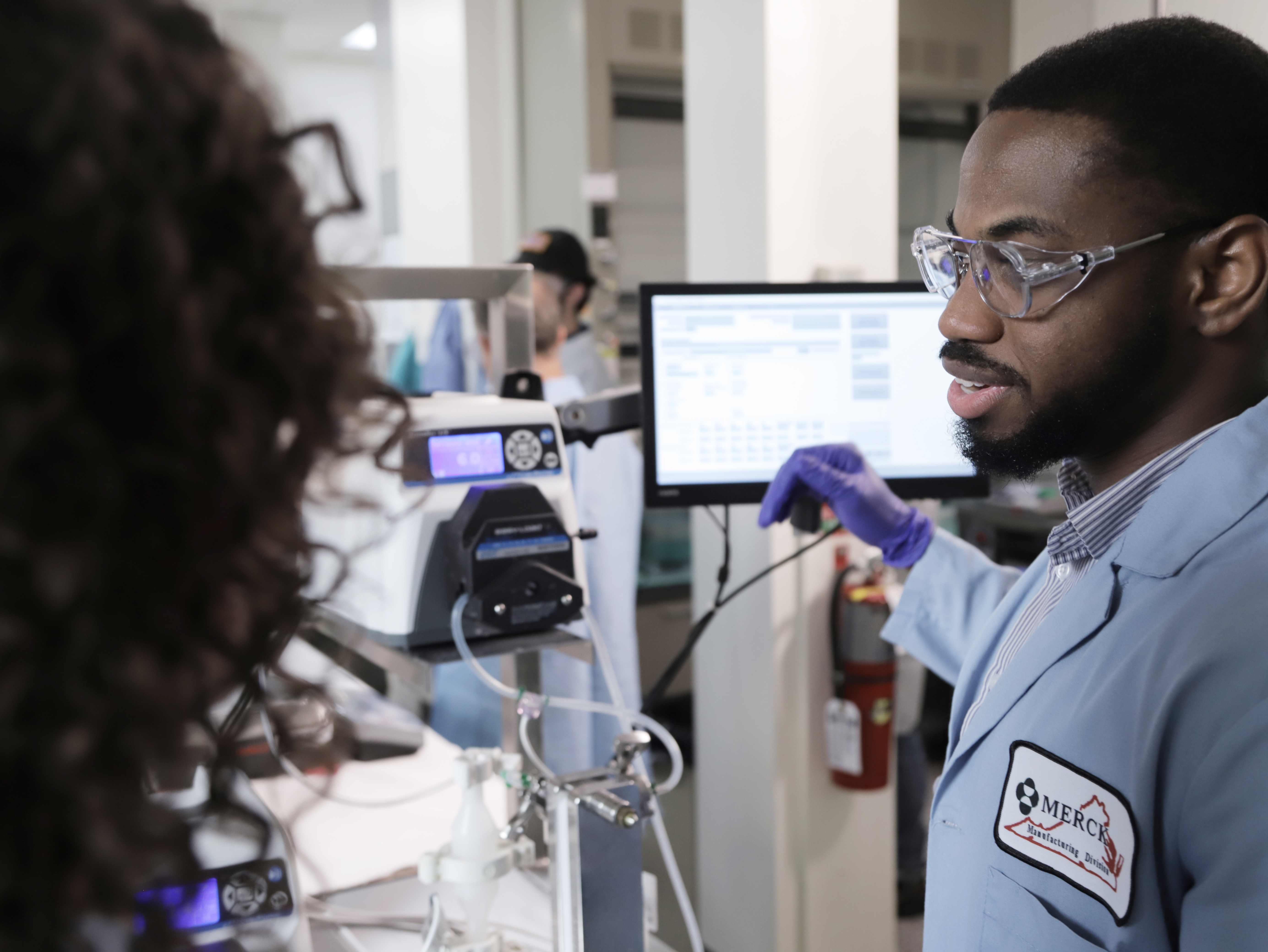 Merck & Co. employees surrounding equipment 