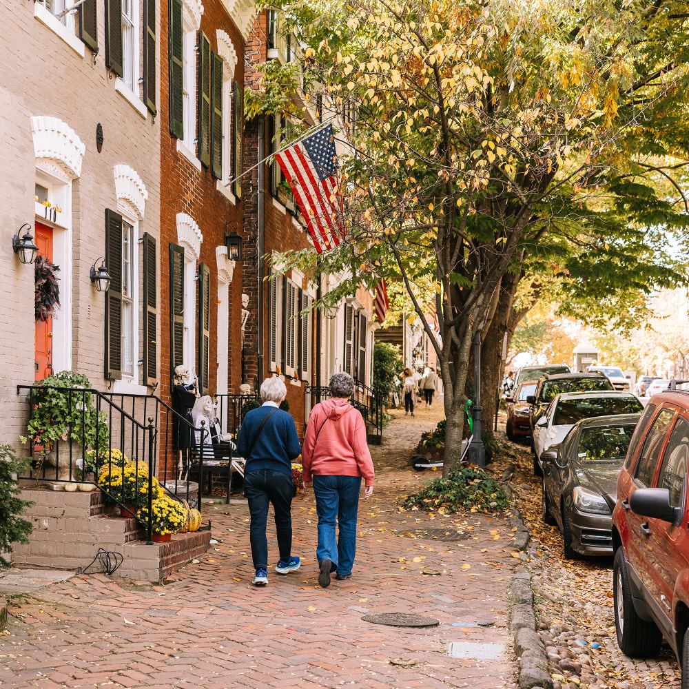 Two people walk down one of Old Town Alexandria's brick sidewalks