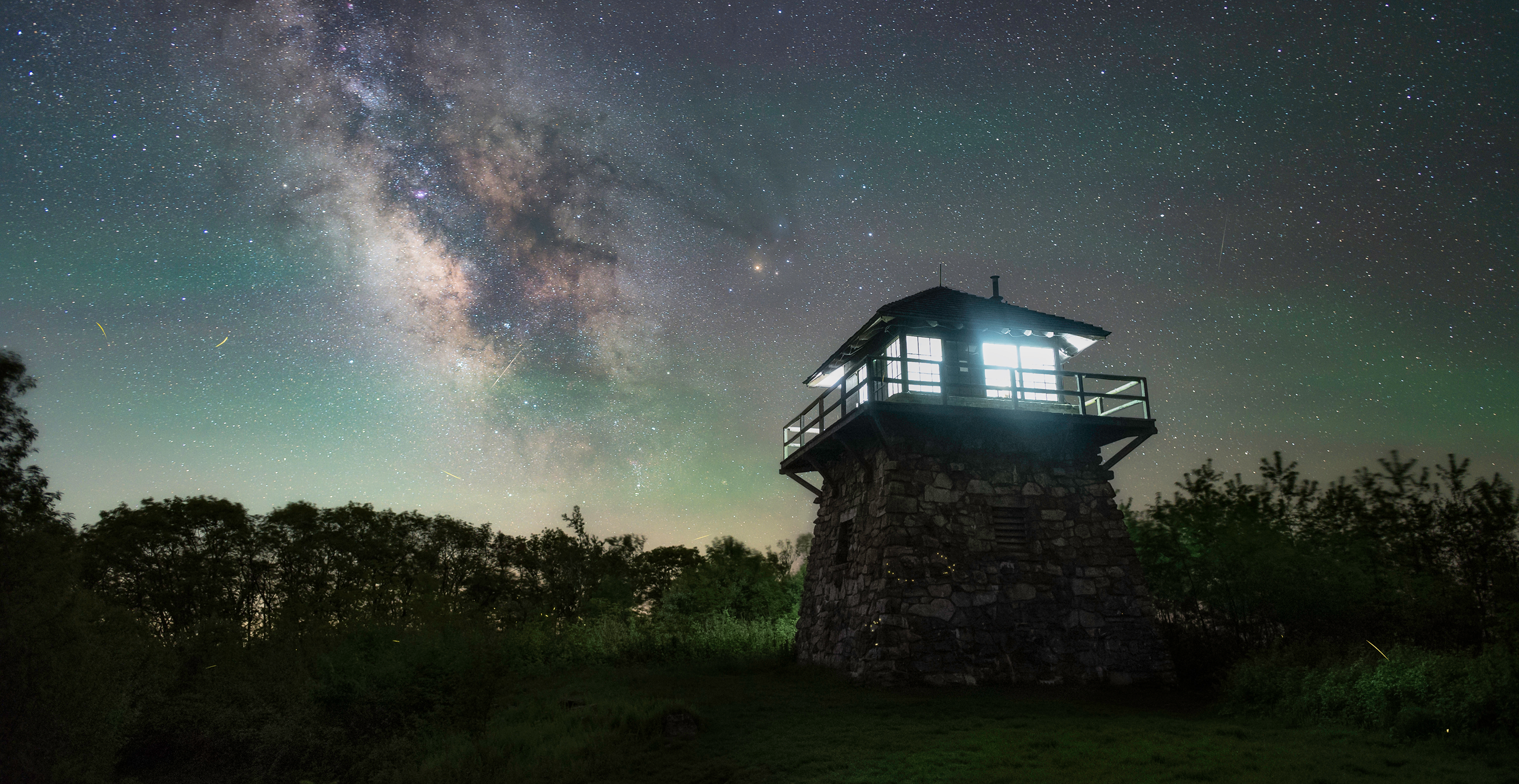 Stone observation tower beneath the Milky Way at night.