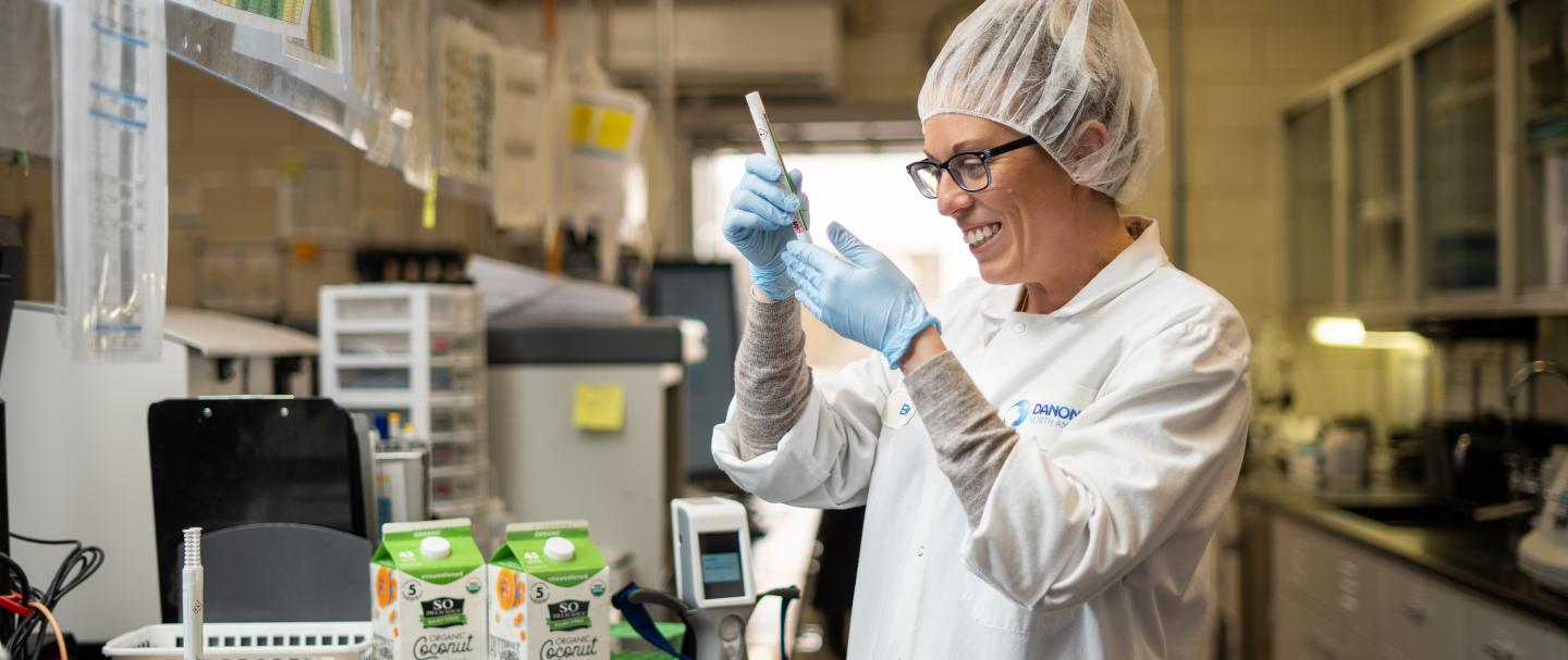 A woman in protective gear looks at a piece of equipment