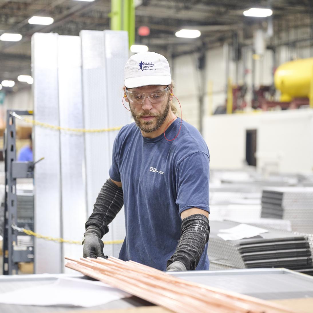 A man handling long metal tubes