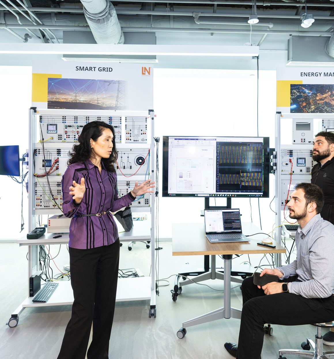 Three people in the Smart Grid lab at George Mason University