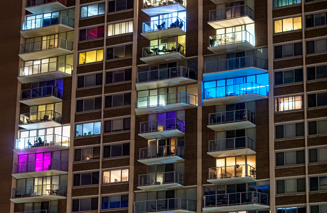 Apartment building balconies illuminated in different colors at night