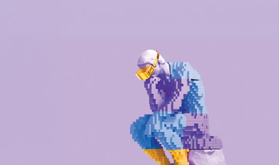 Thinker statue built out of a yellow, light blue and light purple block design