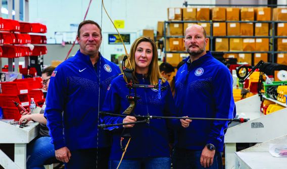 Three T.R.U. ball employees holding a bow and arrow 