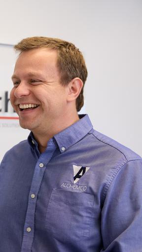 A smiling man working on a computer