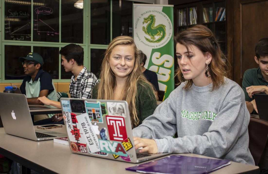 Two students viewing a laptop together. 