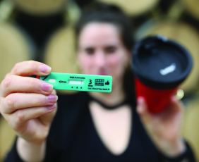 Women holding a drink drug test and cup