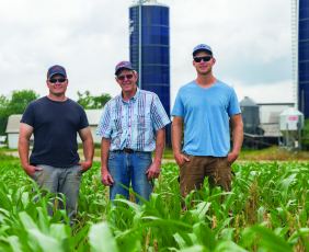 Three men standing in a field at Oakmulgee Dairy Farm