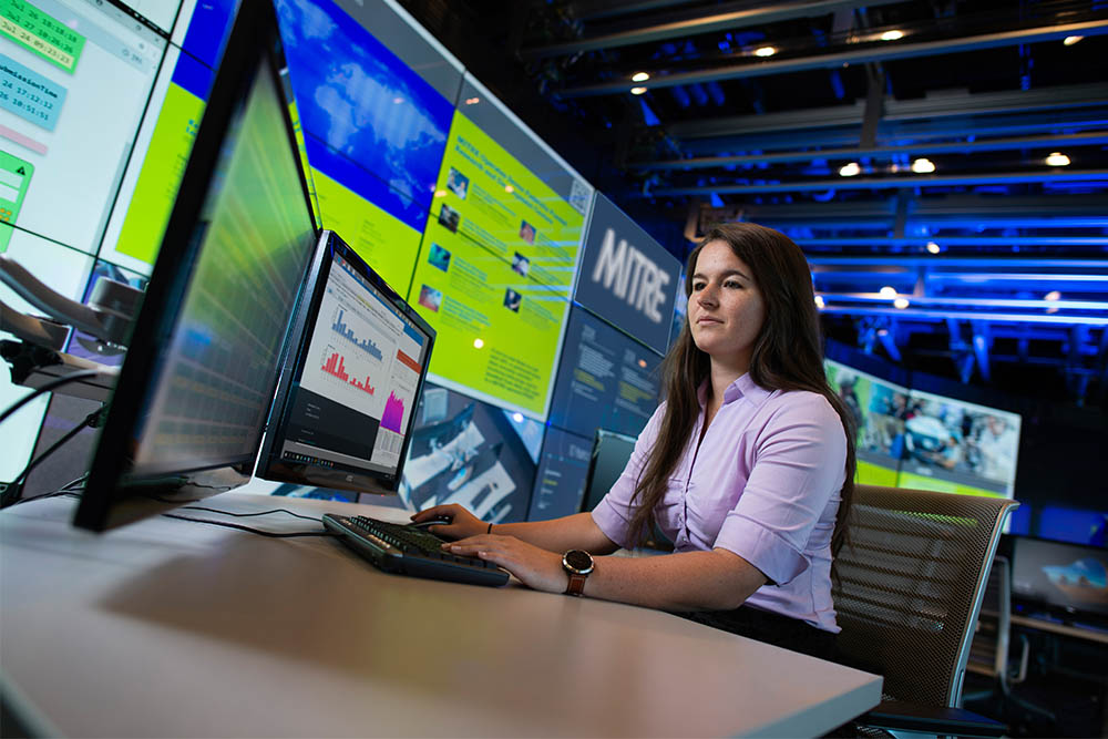 A Mitre female employee sitting at her desk